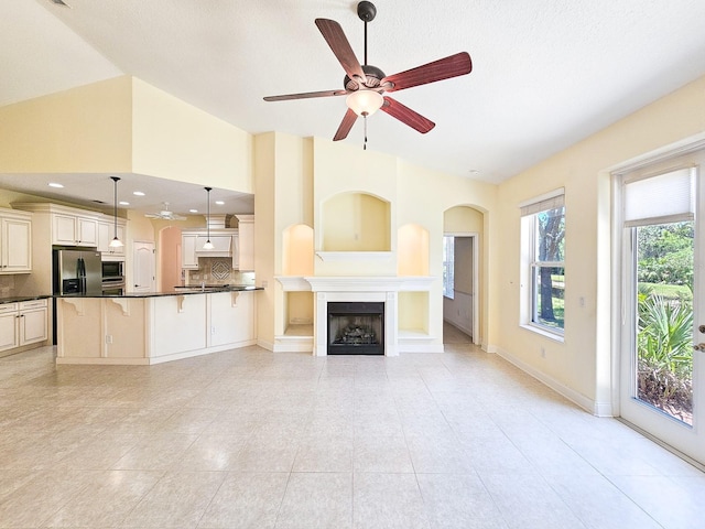 71 N Riverwalk Dr, Palm Coast, FL 32137 - unfurnished living room with a ceiling fan, lofted ceiling, light tile patterned flooring, a fireplace, and baseboards