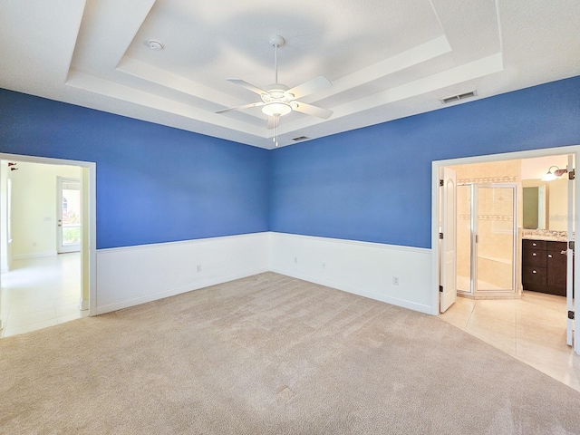 71 N Riverwalk Dr, Palm Coast, FL 32137 - empty room with a raised ceiling, ceiling fan, light tile patterned floors, and light colored carpet