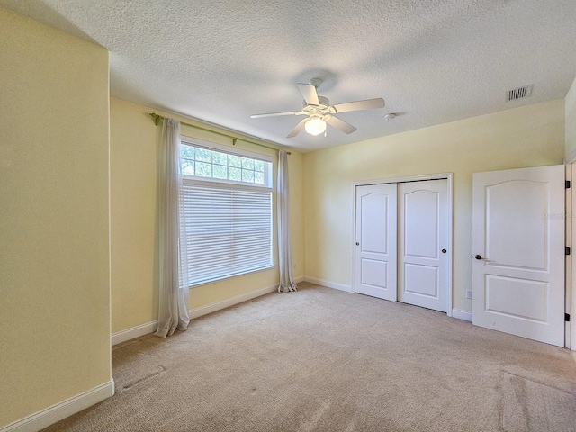 71 N Riverwalk Dr, Palm Coast, FL 32137 - unfurnished bedroom featuring carpet flooring, baseboards, a closet, a textured ceiling, and ceiling fan
