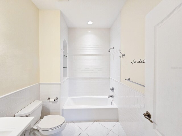 71 N Riverwalk Dr, Palm Coast, FL 32137 - bathroom featuring tile walls, a bathtub, toilet, vanity, and a wainscoted wall