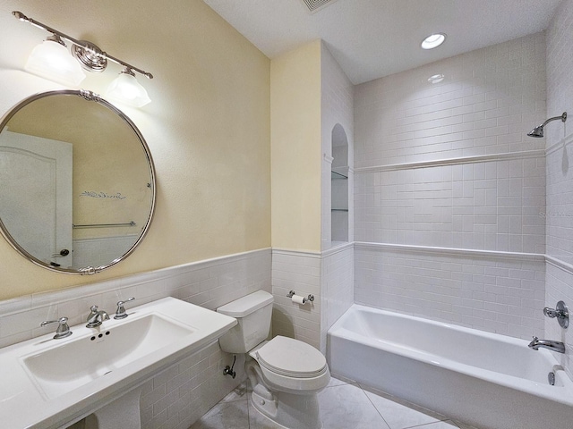 71 N Riverwalk Dr, Palm Coast, FL 32137 - bathroom featuring toilet, tile walls, a sink, shower / bathtub combination, and tile patterned flooring