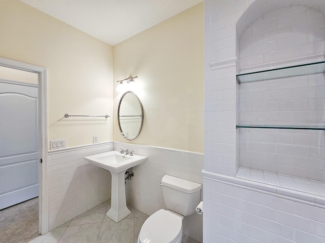 71 N Riverwalk Dr, Palm Coast, FL 32137 - bathroom with tile walls, a wainscoted wall, and toilet