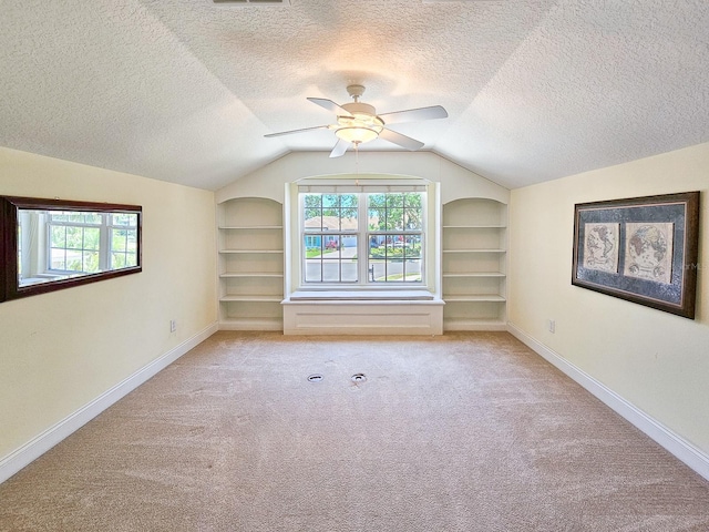71 N Riverwalk Dr, Palm Coast, FL 32137 - bonus room featuring built in shelves, lofted ceiling, baseboards, carpet, and a textured ceiling