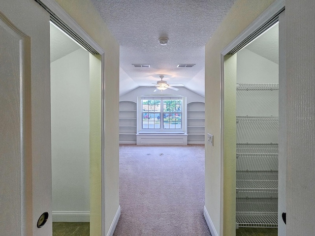 71 N Riverwalk Dr, Palm Coast, FL 32137 - hall featuring vaulted ceiling, a textured ceiling, carpet flooring, and baseboards