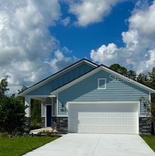 137 Nighthawk Ln, Palm Coast, FL 32164 - view of front facade with stone siding, driveway, and an attached garage