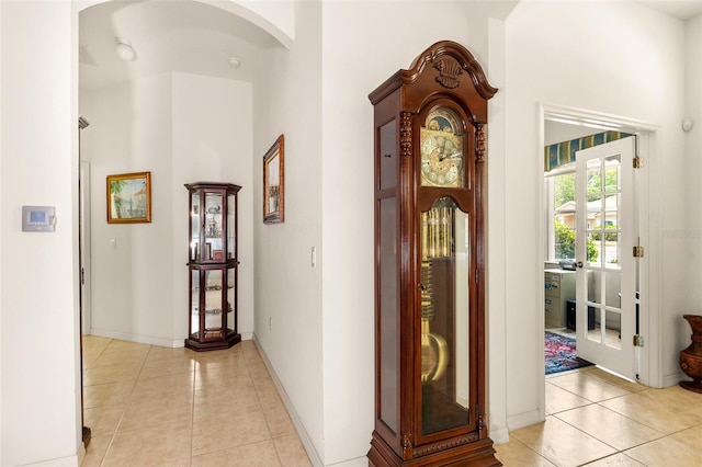 91 Breeze Hill Ln, Palm Coast, FL 32137 - foyer with light tile patterned floors, arched walkways, a high ceiling, and baseboards