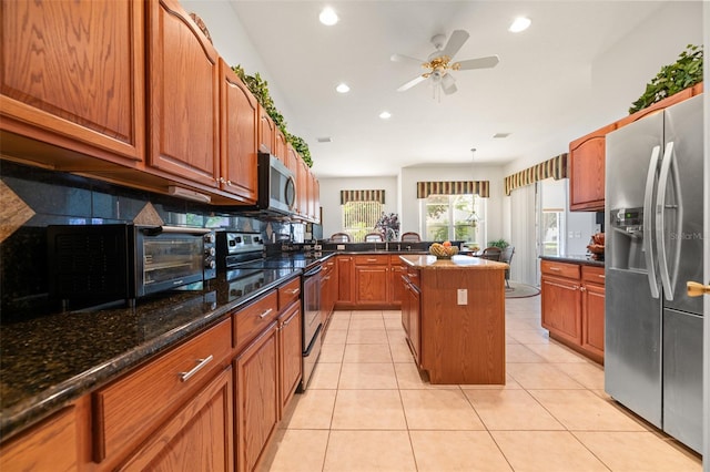 91 Breeze Hill Ln, Palm Coast, FL 32137 - kitchen with stainless steel appliances, recessed lighting, a ceiling fan, brown cabinetry, and decorative backsplash