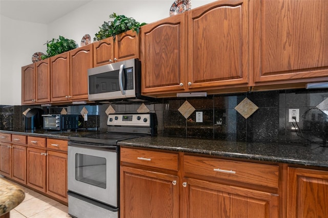 91 Breeze Hill Ln, Palm Coast, FL 32137 - kitchen with appliances with stainless steel finishes, tasteful backsplash, dark stone counters, and brown cabinets