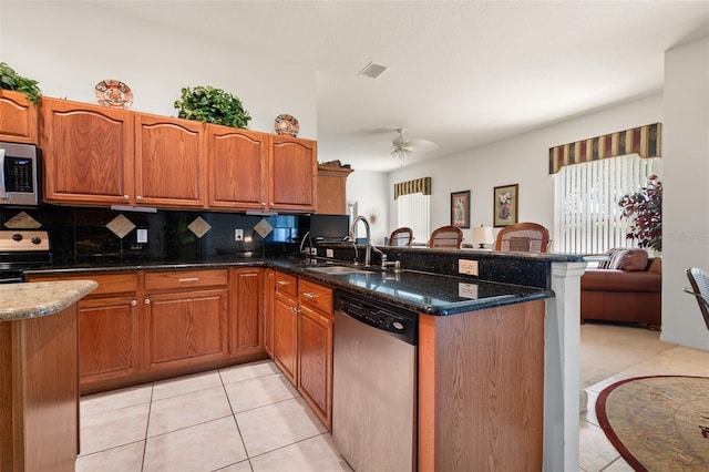 91 Breeze Hill Ln, Palm Coast, FL 32137 - kitchen featuring stainless steel appliances, a sink, a peninsula, a ceiling fan, and backsplash