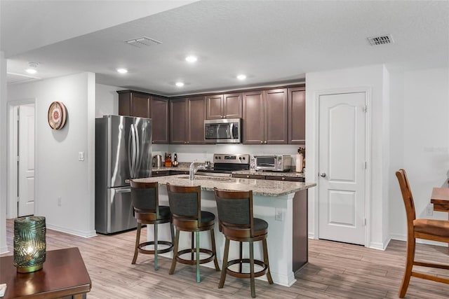 9 Waldron Pl, Palm Coast, FL 32164 - kitchen featuring appliances with stainless steel finishes, dark brown cabinets, light wood finished floors, baseboards, and recessed lighting