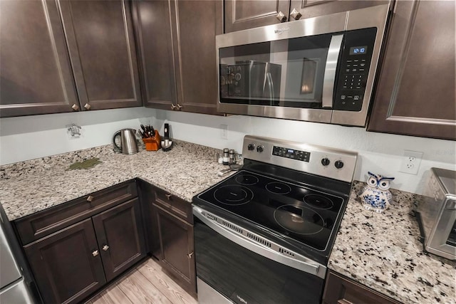 9 Waldron Pl, Palm Coast, FL 32164 - kitchen with appliances with stainless steel finishes, dark brown cabinets, and light stone countertops