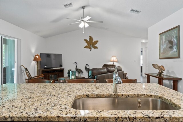 9 Waldron Pl, Palm Coast, FL 32164 - kitchen featuring a sink, light stone counters, a ceiling fan, open floor plan, and vaulted ceiling