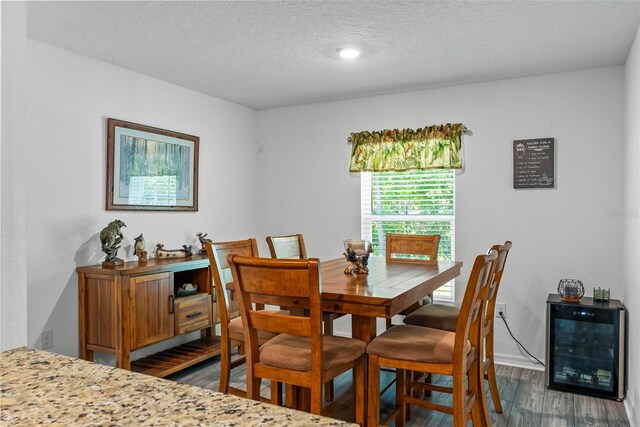 9 Waldron Pl, Palm Coast, FL 32164 - dining space featuring wine cooler, wood finished floors, a textured ceiling, and baseboards