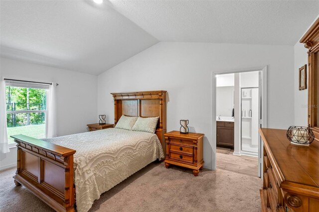 9 Waldron Pl, Palm Coast, FL 32164 - bedroom featuring vaulted ceiling, light carpet, and ensuite bath