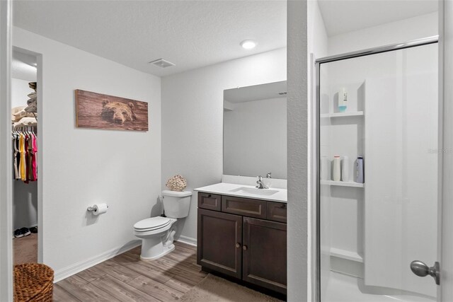 9 Waldron Pl, Palm Coast, FL 32164 - full bath featuring toilet, wood finished floors, vanity, a shower with shower door, and a walk in closet