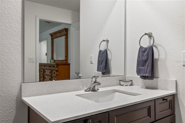 9 Waldron Pl, Palm Coast, FL 32164 - bathroom featuring a textured wall and vanity