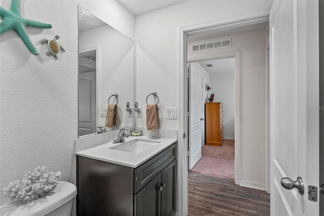 9 Waldron Pl, Palm Coast, FL 32164 - half bath featuring wood finished floors, vanity, toilet, and a textured wall