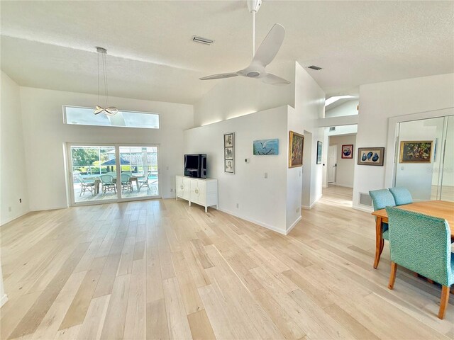 4 Cotton Ct, Palm Coast, FL 32137 - living area featuring light wood-type flooring, ceiling fan, high vaulted ceiling, baseboards, and a textured ceiling
