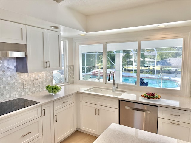 4 Cotton Ct, Palm Coast, FL 32137 - kitchen with dishwasher, a sink, ventilation hood, black electric cooktop, and white cabinetry