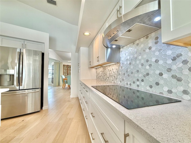 4 Cotton Ct, Palm Coast, FL 32137 - kitchen with stainless steel fridge, range hood, black electric cooktop, tasteful backsplash, and light wood-type flooring