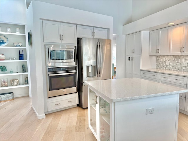 4 Cotton Ct, Palm Coast, FL 32137 - kitchen with appliances with stainless steel finishes, light wood-style flooring, open shelves, and light stone countertops