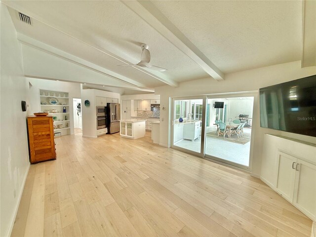 4 Cotton Ct, Palm Coast, FL 32137 - unfurnished living room with light wood finished floors, a textured ceiling, a ceiling fan, baseboards, and a sink