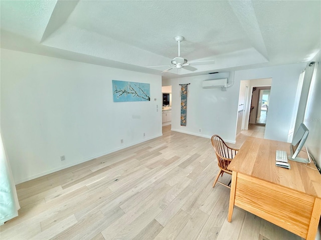 4 Cotton Ct, Palm Coast, FL 32137 - home office featuring a tray ceiling, a wall unit AC, light wood-style flooring, ceiling fan, and a textured ceiling