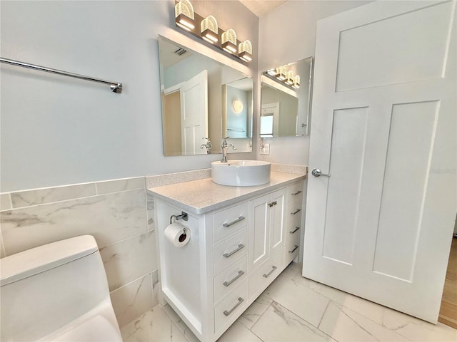 4 Cotton Ct, Palm Coast, FL 32137 - bathroom with marble look tile flooring, vanity, toilet, and a wainscoted wall