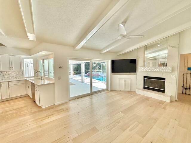 4 Cotton Ct, Palm Coast, FL 32137 - unfurnished living room with a sink, a textured ceiling, light wood-style floors, beam ceiling, and ceiling fan