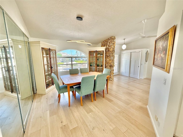4 Cotton Ct, Palm Coast, FL 32137 - dining space featuring a textured ceiling, light wood-type flooring, vaulted ceiling, and baseboards