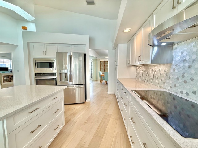 4 Cotton Ct, Palm Coast, FL 32137 - kitchen featuring stainless steel appliances, ventilation hood, light wood-type flooring, a skylight, and backsplash