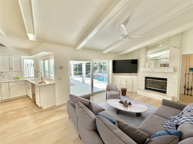 4 Cotton Ct, Palm Coast, FL 32137 - living area with a textured ceiling, light wood-style floors, beamed ceiling, a high end fireplace, and a ceiling fan