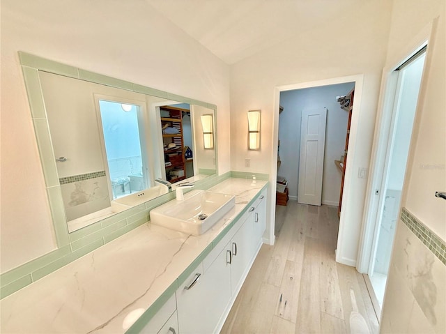 4 Cotton Ct, Palm Coast, FL 32137 - full bathroom with wood finished floors, a spacious closet, vanity, and vaulted ceiling