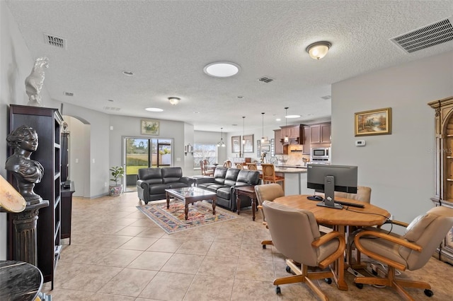 123 N Starling Dr, Palm Coast, FL 32164 - living area with arched walkways, a textured ceiling, and light tile patterned flooring