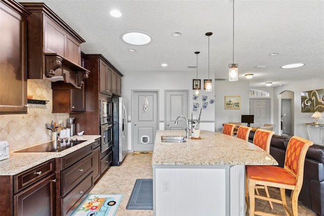 123 N Starling Dr, Palm Coast, FL 32164 - kitchen with a sink, stainless steel appliances, a kitchen bar, tasteful backsplash, and open floor plan