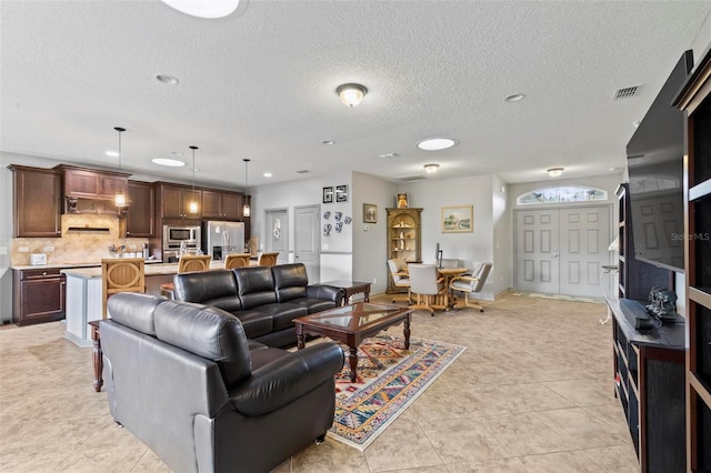123 N Starling Dr, Palm Coast, FL 32164 - living room featuring light tile patterned floors, a textured ceiling, and recessed lighting