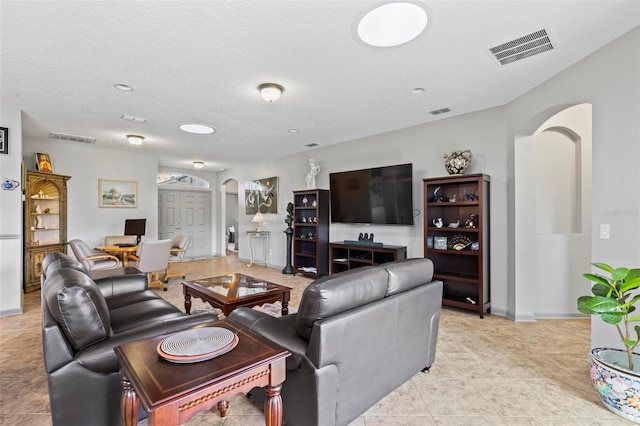 123 N Starling Dr, Palm Coast, FL 32164 - living room with arched walkways, baseboards, a textured ceiling, recessed lighting, and light tile patterned flooring