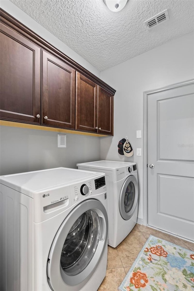 123 N Starling Dr, Palm Coast, FL 32164 - laundry room with cabinet space, independent washer and dryer, light tile patterned floors, and a textured ceiling
