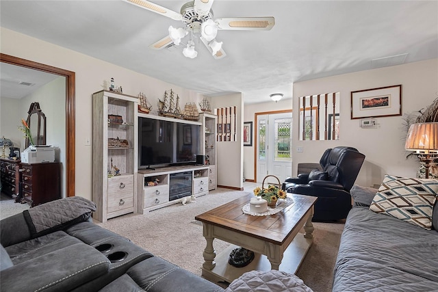 living area with light carpet and ceiling fan