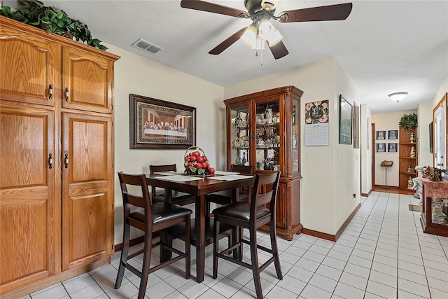 dining area with ceiling fan, light tile patterned flooring, and baseboards
