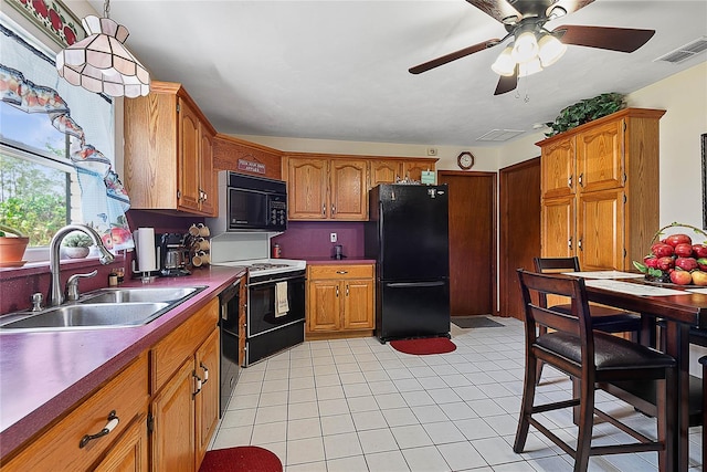 kitchen featuring black appliances, a sink, brown cabinets, ceiling fan, and dark countertops