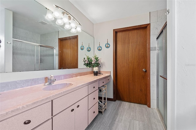 bathroom featuring a shower stall and vanity