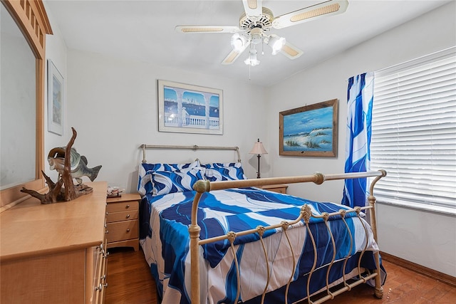 bedroom with wood finished floors, baseboards, and a ceiling fan