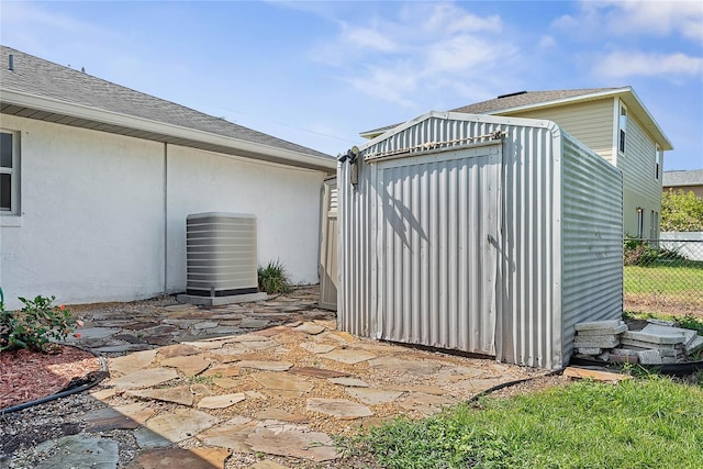 view of shed featuring fence and central AC