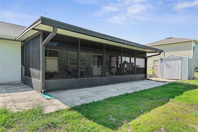 rear view of property with a sunroom, a storage shed, an outdoor structure, and a yard
