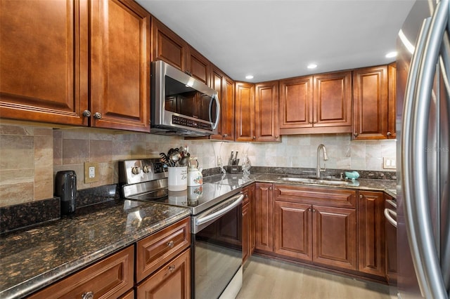 3580 S Ocean Shore Blvd Unit 210, Flagler Beach, FL 32136 - kitchen with stainless steel appliances, a sink, dark stone counters, decorative backsplash, and light wood finished floors