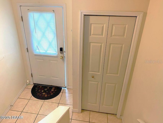 entryway with light tile patterned flooring and baseboards
