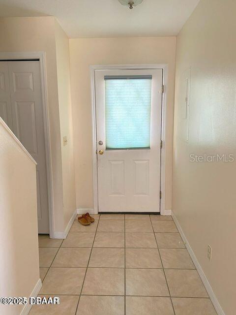 entryway with light tile patterned flooring and baseboards