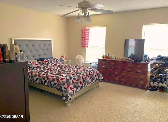 bedroom featuring multiple windows, light colored carpet, and ceiling fan
