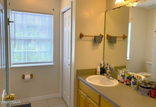 bathroom featuring tile patterned flooring, toilet, vanity, and baseboards